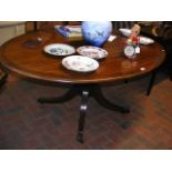 An oval Regency mahogany dining table with cross b