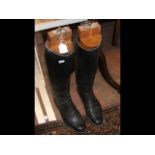 A pair of vintage leather riding boots with wooden