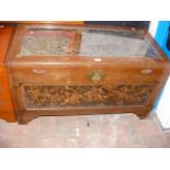 A carved oriental blanket chest with panels depict