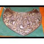 An antique military breast plate, depicting a batt