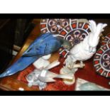 A porcelain parrot figure, together with two other
