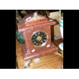 A rouge marble cased striking mantle clock
