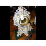 A striking mantle clock in ornate cherub and flowe