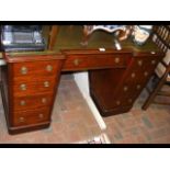 An antique break front pedestal desk with green le