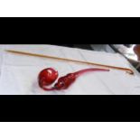 A cranberry glass pipe - L72cm, together with a gl