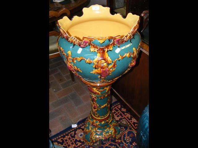 A glazed pottery jardiniere and stand with ornate