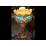 A glazed pottery jardiniere and stand with ornate