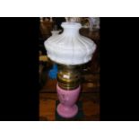 A floral decorated pink glass oil lamp with emboss