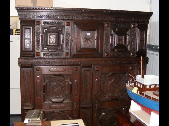 A large antique carved continental oak cupboard wi