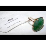 An oval jade ring in gold setting
