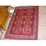 A Turkish rug with red ground and geometric border