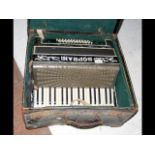A Soprani piano accordion in carrying case