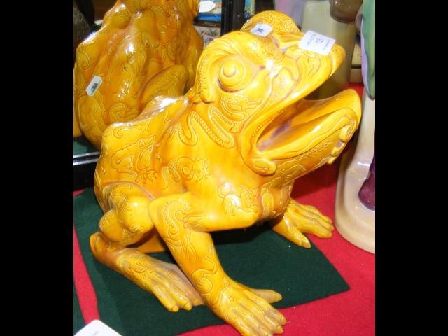 An antique orange glazed frog figure with impresse