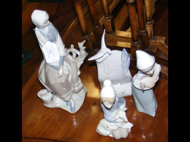 A Lladro seated female figure, together with three