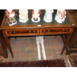 An Edwardian two drawer writing desk, with cross b