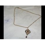 An elegant Edwardian 9ct gold pendant with garnet