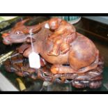 A 28cm long carved oriental wooden Buffalo ornament on stand