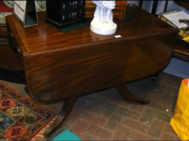 A 19th century drop-leaf mahogany dining table, on