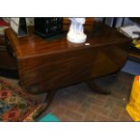 A 19th century drop-leaf mahogany dining table, on