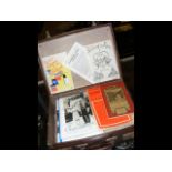 A small suitcase containing vintage books, magazin