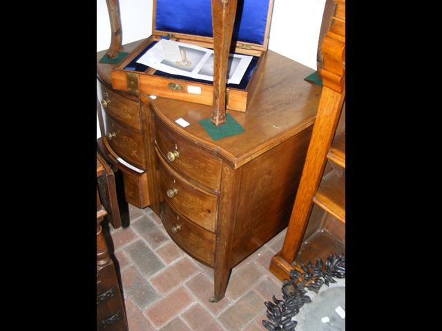 A mahogany chest of drawers with shaped front - wi