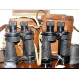 A pair of binoculars in fitted leather case and on