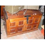 A dome top teak storage trunk with metal handles a