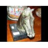A bronze style 'horse head' on marble plinth