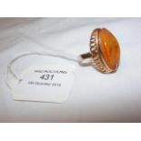 A lady's oval amber dress ring in gold setting