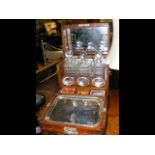 An antique three bottle tantalus and games compend