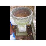 A stone plant pot on plinth