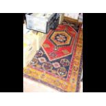 A Middle Eastern rug with geometric border and red