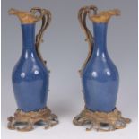 A PAIR OF LATE 19TH CENTURY FRENCH ORMOLU MOUNTED PORCELAIN EWERS with blue mottled ground and