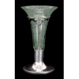 AN ART NOUVEAU LIBERTY STYLE TUDRIC PEWTER TRUMPET VASE of beaten design with green Clutha glass