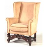 A 17TH CENTURY OAK WINGBACK ARMCHAIR with upholstered back, scrolled arms and loose cushion;