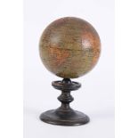AN EARLY 19TH CENTURY MINIATURE TERRESTRIAL DESK GLOBE 3 inches in diameter on a turned ebonised