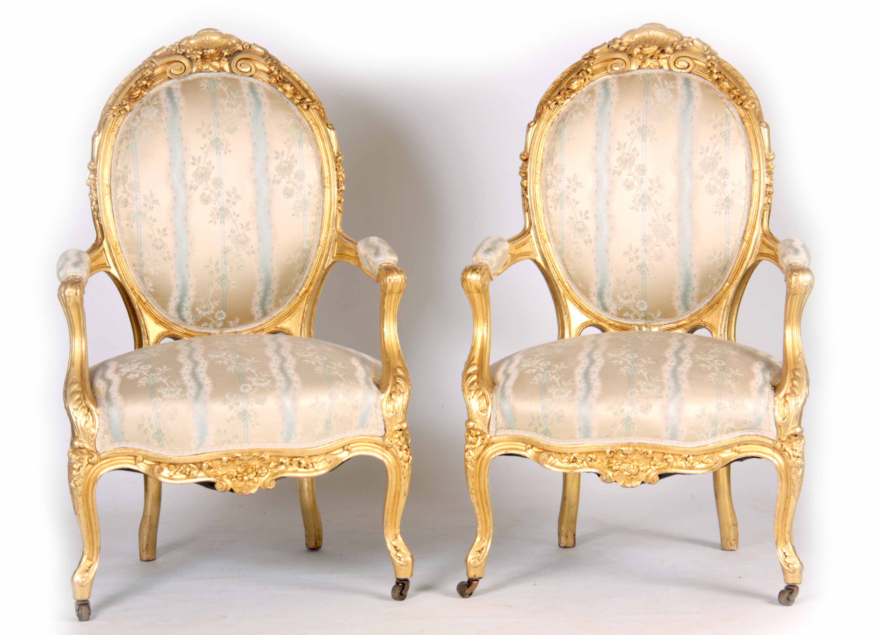 A PAIR OF 19TH CENTURY FRENCH LOUIS XVI GILT GESSO CARVED ARMCHAIRS with flower head carved