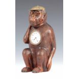 A LATE 19TH CENTURY BLACK FOREST CARVED NOVELTY MONKEY CLOCK the seated monkey with inset amber