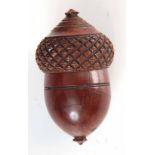 A 19TH CENTURY TURNED COQUILLA NUT NUTMEG GRATER in the form of an acorn, 7cm high, 4cm wide.