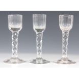 A SET OF THREE 18TH CENTURY CORDIAL GLASSES with facet cut stems and bowls, on plain bases 13cm