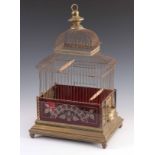 A VICTORIAN BRASS AND CRANBERRY GLASS BIRDCAGE having a brass finial above a pagoda style frame on