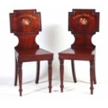 A PAIR OF LATE GEORGIAN MAHOGANY HALL CHAIRS with painted backs reading Castle Howard with coats