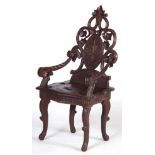 A LATE 19TH CENTURY CARVED WALNUT BLACK FOREST CHILDS ARM CHAIR having scrolling branches and carved