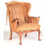 A GEO I STYLE WALNUT WINGBACK ARMCHAIR with out swept back and scrolled arms; standing on shaped