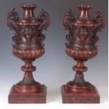 A PAIR OF LATE 19TH CENTURY FRENCH CARVED WALNUT LIDDED URNS with acanthus leaf decoration and