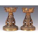 A PAIR OF EARLY 19TH CENTURY GILT ORMOLU FIRE DOGS having rococo style leaf cast mounts on