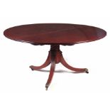 A LARGE GEORGE III FIGURED MAHOGANY CIRCULAR DINING TABLE with book matched two-piece top above a