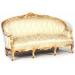 A 19TH CENTURY FRENCH LOUIS XVI STYLE GILT GESSO CARVED SETTEE with flower head carved decoration,