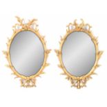 A PAIR OF 18TH CENTURY CARVED GILTWOOD OVAL HANGING MIRRORS with simulated branch work frames 92cm