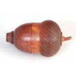 A 19TH CENTURY TURNED COQUILLA NUT NUTMEG GRATER in the form of an acorn, 7cm high, 4.5cm wide.